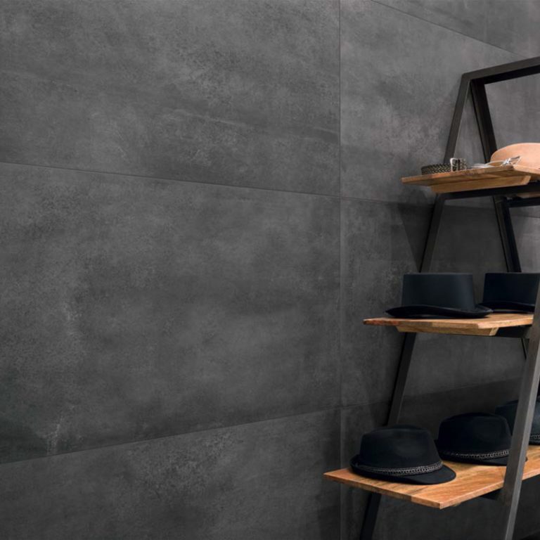 Urbana 12x24 Antracite concrete-look porcelain wall tile behind a wood display ladder