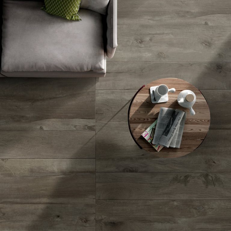 Overhead view of a Colville 8x48 Gray wood-look porcelain floor with a side table