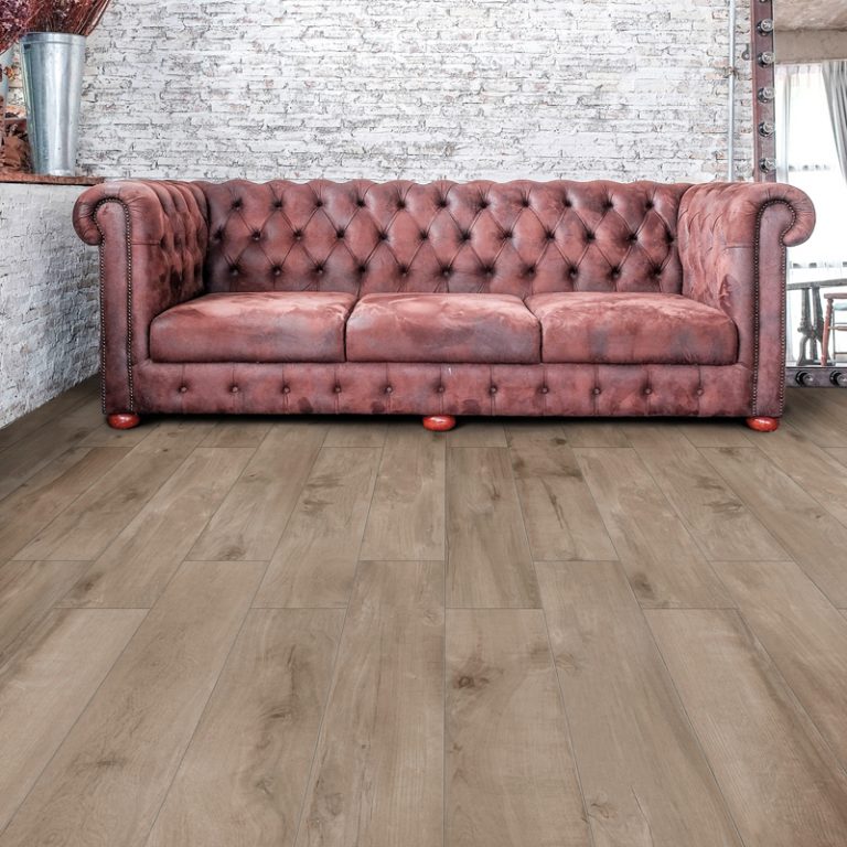 Living room with a Colville 8x48 Taupe wood-look porcelain floor and a leather chesterfield sofa