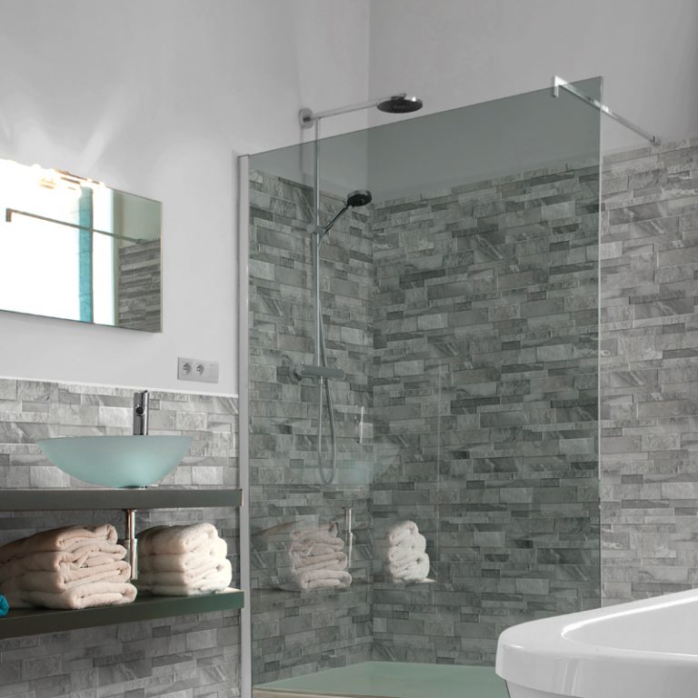 Shower with Marmi Gray marble-look interlocking porcelain wall panels and an inside mitered corner