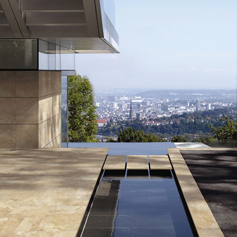 Terrace with Navona Travertine 24x24 and Roman pattern porcelain pavers beside a reflecting pool