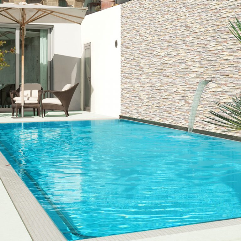 Pool with a water feature wall in Natura Tropical stone-look interlocking porcelain wall panels