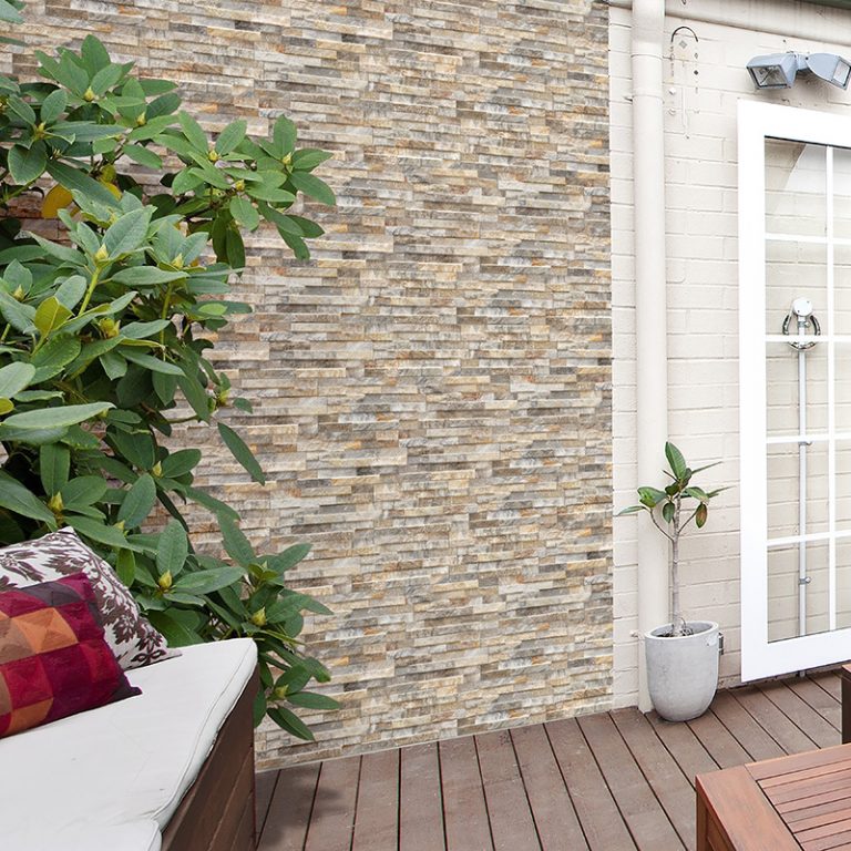 Garden wall in Natura Deserto stone-look interlocking porcelain wall panels beside a wood deck