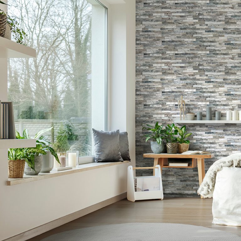 Bedroom with a Natura Giungla accent wall in stone-look interlocking porcelain wall panels by a window