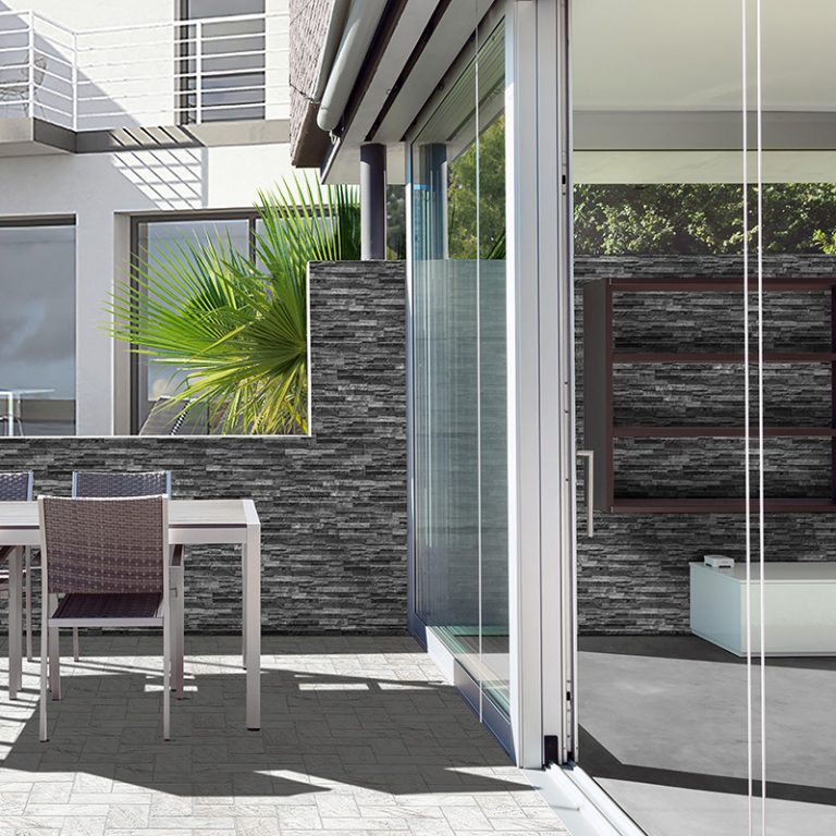 Patio with a Natura Lava wall in stone-look interlocking porcelain wall panels beside sliding glass doors
