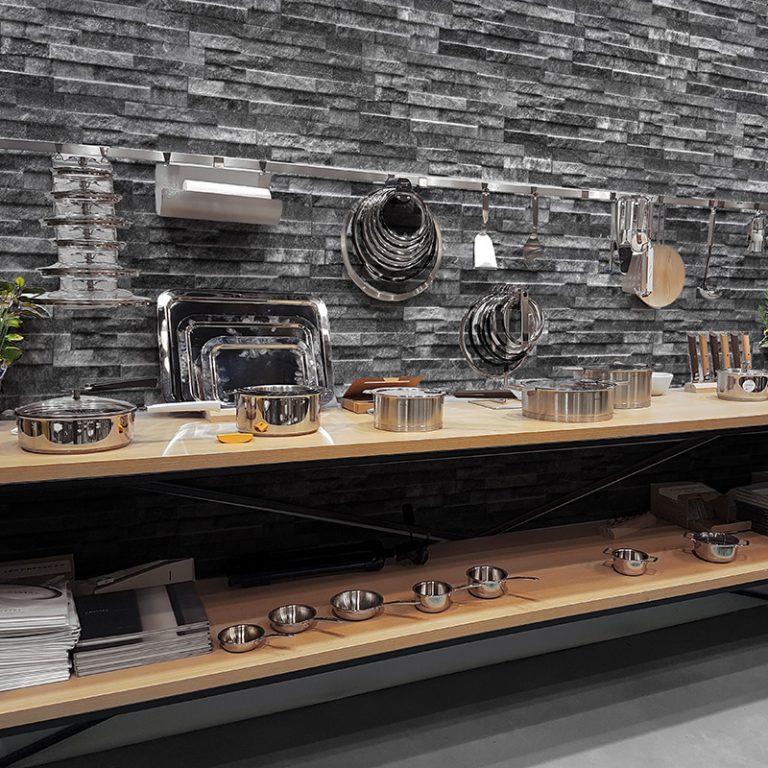Kitchen wall in Natura Lava stone-look interlocking porcelain wall panels with wood shelves