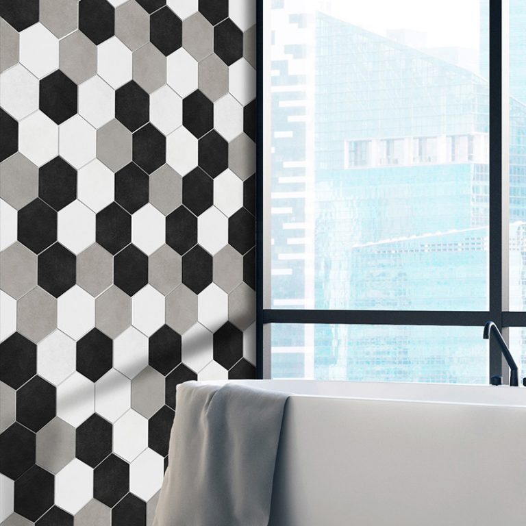Bathroom wall in Colors black, white and greige hexagon tile beside a freestanding tub
