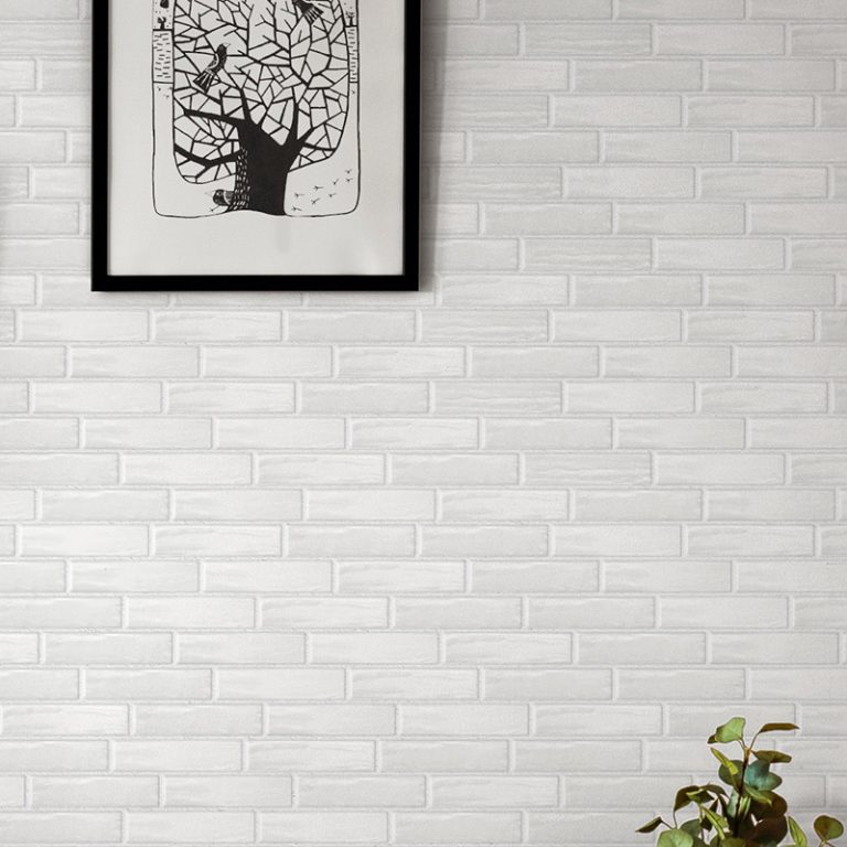 Close-up of a Colors 2-3/8x9-7/8 White glossy brick tile wall with framed art