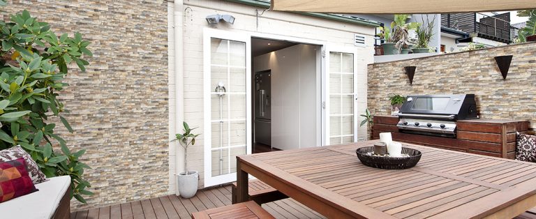 Backyard deck with a garden wall in Natura Deserto stone-look interlocking porcelain wall panels