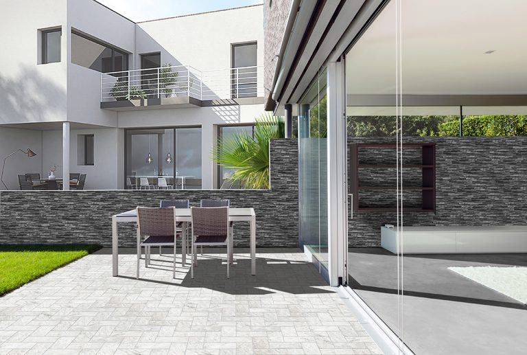 Patio wall in Natura Lava stone-look interlocking porcelain wall panels beside a glass sliding door