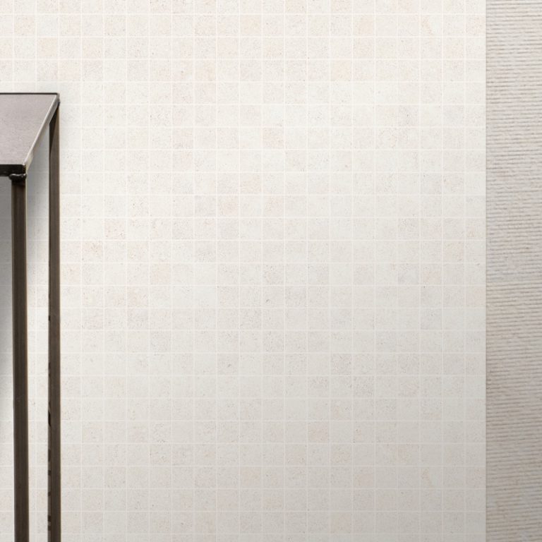 Silky Stone Light 24x48 porcelain tile and 2x2 mosaic wall beside a doorway
