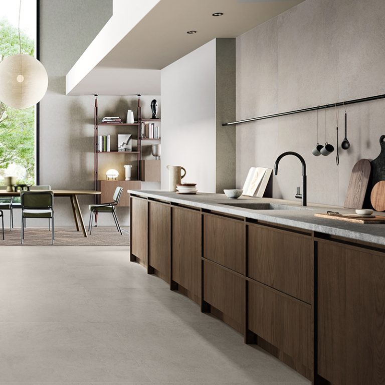 Kitchen with a long wood island on a Silky Stone Greige porcelain tile floor