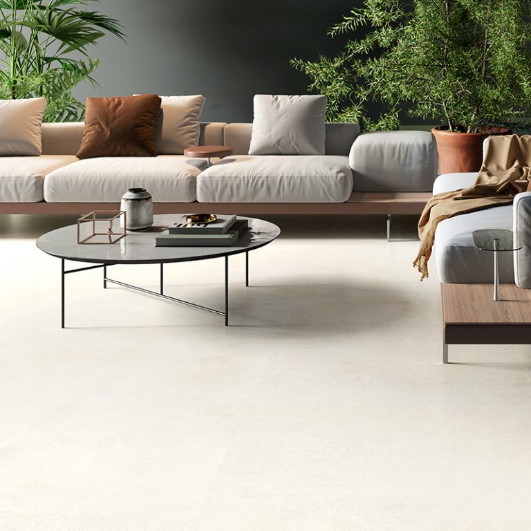 Living room with a Silky Stone Light 24x48 porcelain tile floor and a white sectional sofa