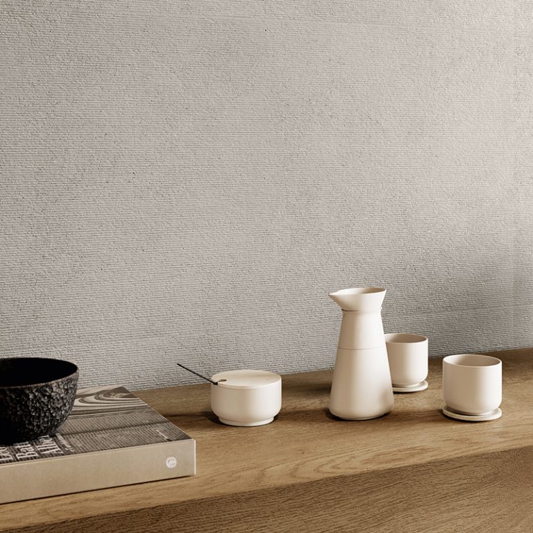 Kitchen wall in Silky Stone Greige 24x48 porcelain tile above a wood counter with pottery