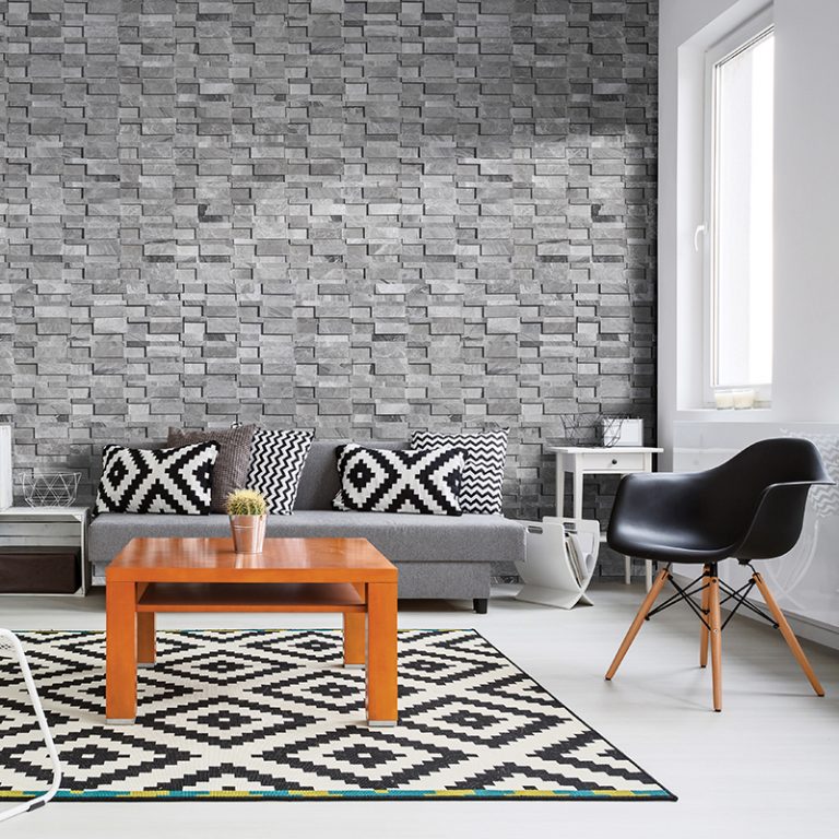 Living room feature wall in Niobe Gray 7x20 honed 3D interlocking marble ledger panels