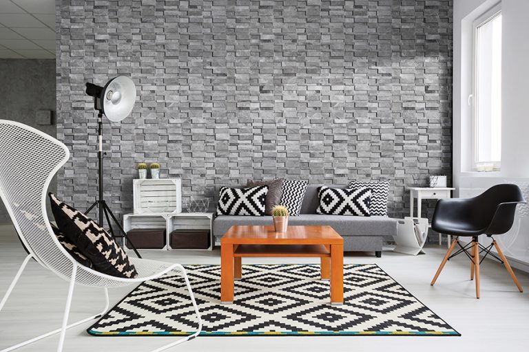 Living room with a Niobe Gray 3D interlocking marble ledger panel wall in 7x20 and 6x24