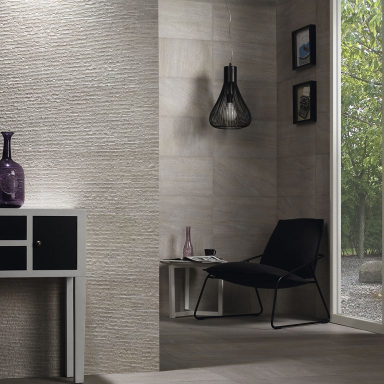 Ontario 12x22 Gris raked stone-look wall panels behind a console and a black lounge chair