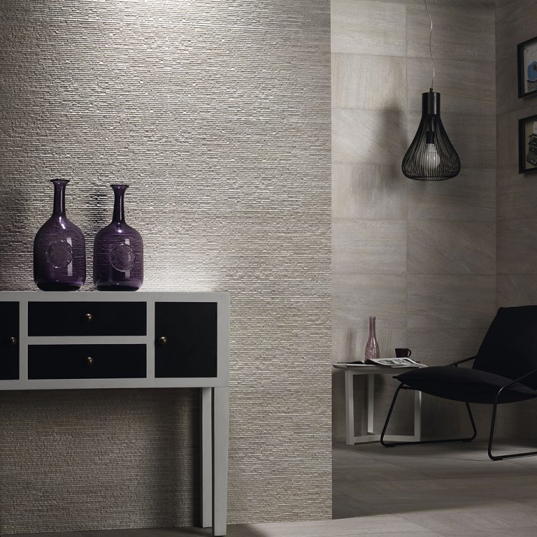 Living room with Ontario 12x22 Gris raked stone-look wall panels behind a black console