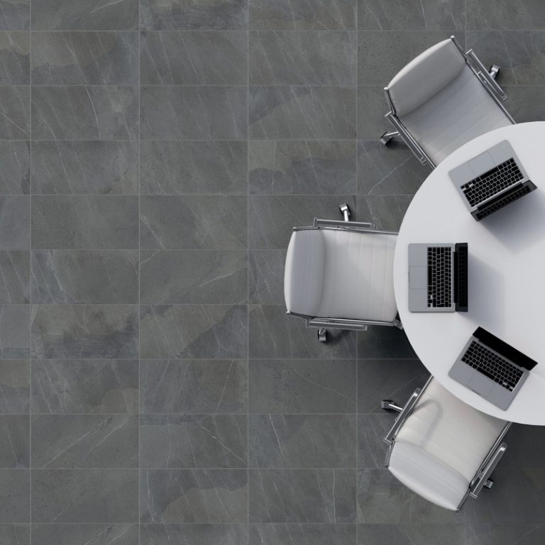 Overhead view of an Allure 12x24 Dusk dark gray porcelain tile floor with a round table