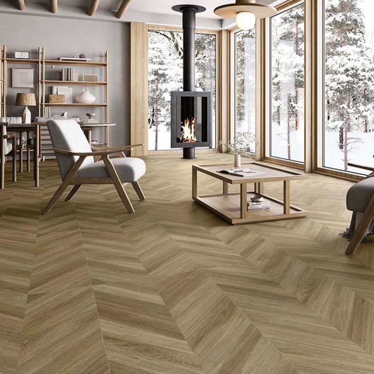Open living room with a Baywood Manhattan Natural wood-look porcelain chevron floor and large windows