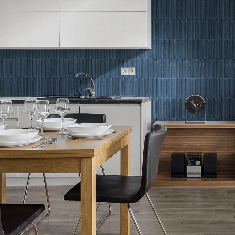 Kitchen backsplash in Posh Pitch 3D navy glossy porcelain tile behind a wood dining table