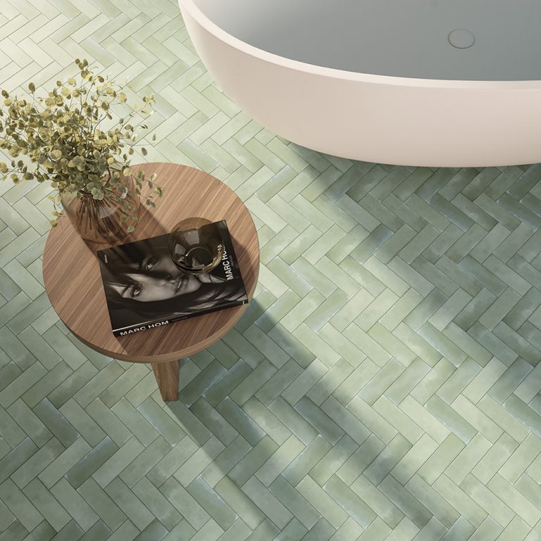 Refined 2x6 green porcelain tile floor in a herringbone pattern beside a freestanding tub
