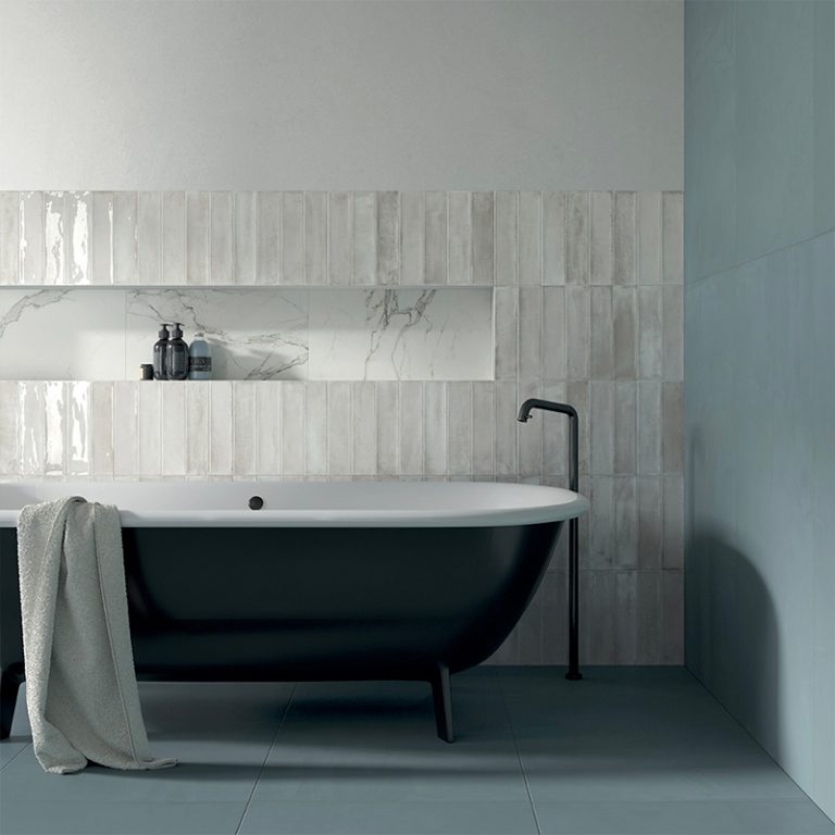 Bathroom with Stack 12x24 white glossy porcelain wall tile and a black freestanding tub