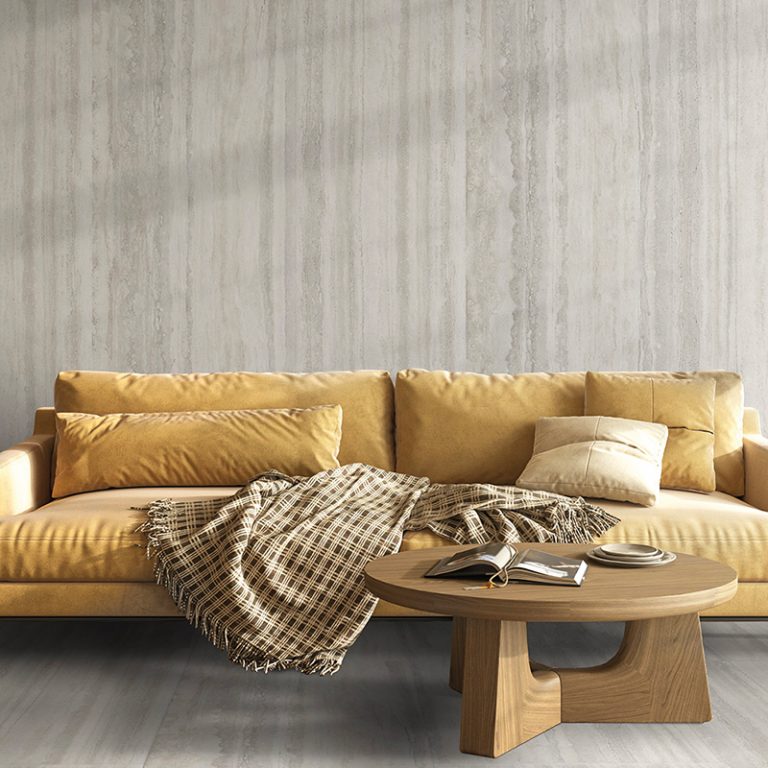 Living room with Veneto 24x48 Light travertine-look porcelain wall tile behind a yellow sofa