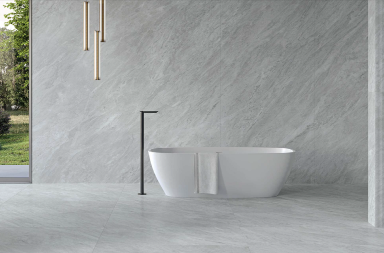 Bathroom with Pietrasanta Bianco 24x48 marble-look porcelain tile on the walls and floor and a freestanding tub