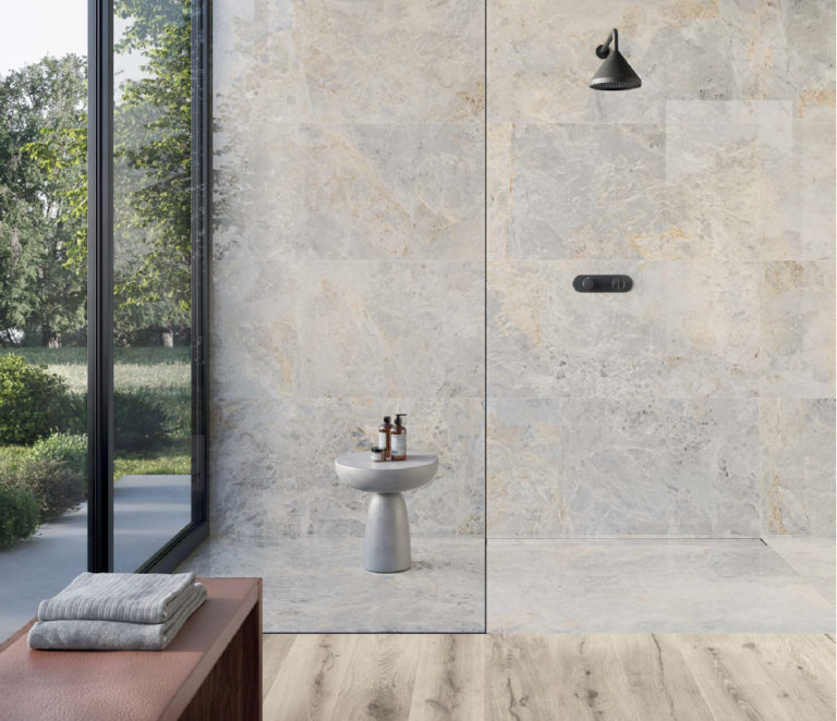 Walk-in shower with Pietrasanta Ivory 24x48 porcelain tile on the walls and floor beside a glass wall to the garden