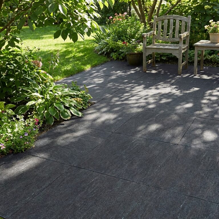 Garden patio in 24x24 Nextone Black porcelain pavers with a wooden bench and planted border