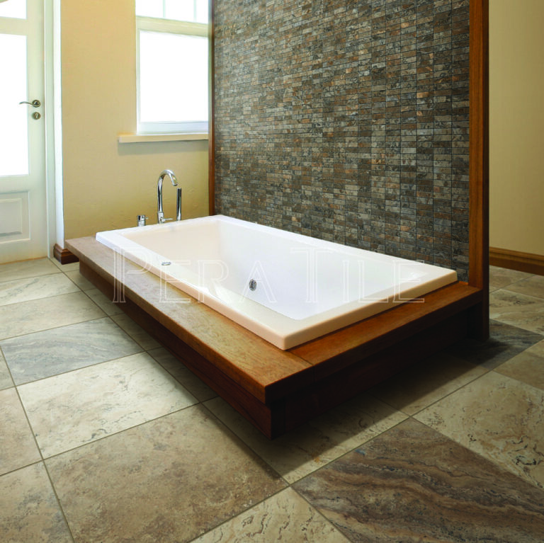 Bathroom with a drop-in tub on a wood platform beside a mosaic accent wall and Alchemy Travertine floor tile