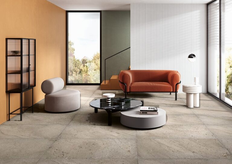 Living room with a Petravera Terrafina 24x48 Taupe stone-look porcelain tile floor and an orange sofa