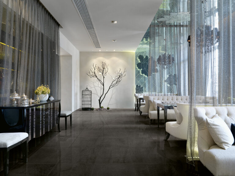 Dining lounge with white tufted banquettes on Sublime black porcelain floor tile